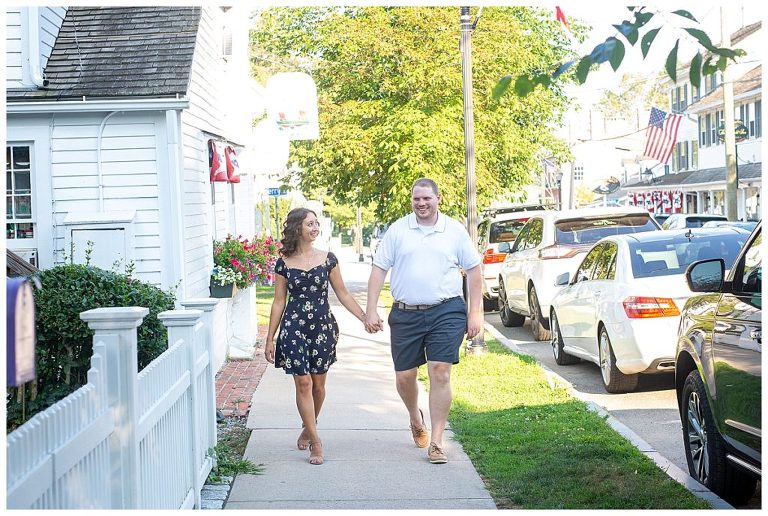 couple holding hands and walking down the sidewalk
